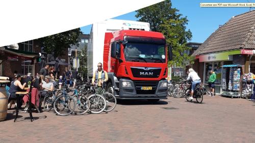 Vrachtwagen en fietsers midden in het dorp